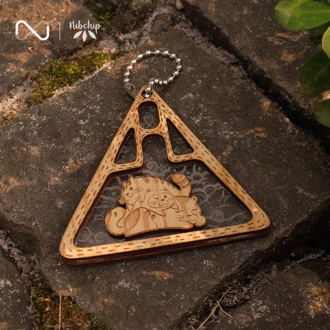 cat family wooden keychain on ground