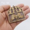 racoon family wooden keychain on hand isolated