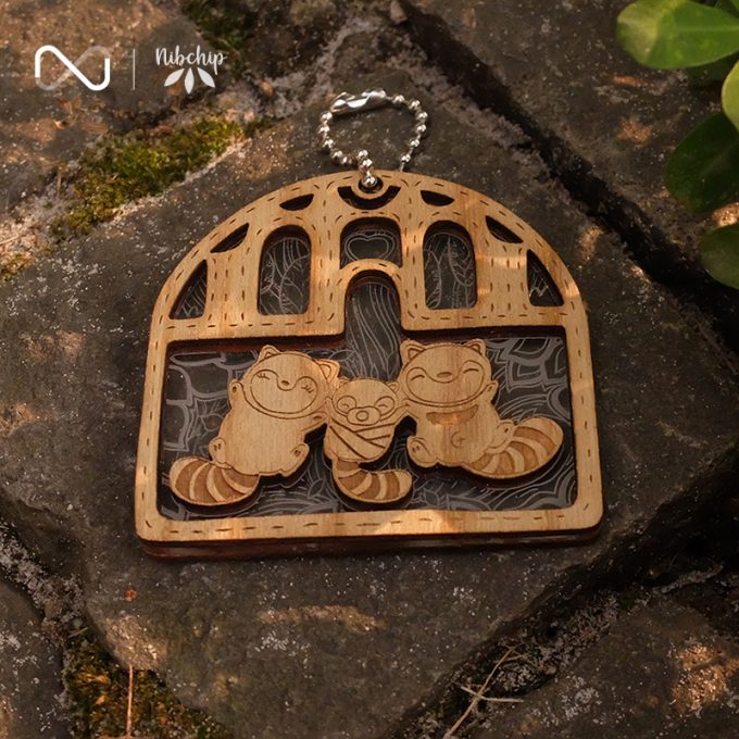 raccoon family wooden keychain light on ground